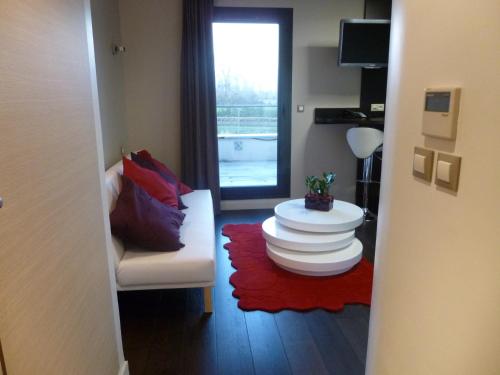 un soggiorno con un divano bianco e un tavolo di Logis Hôtel Terre de Loire a Belleville-sur-Loire