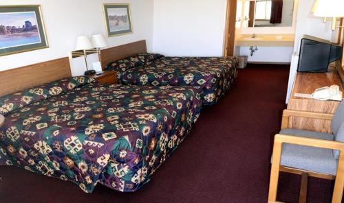 a hotel room with two beds and a television at Yorkshire Motel in York