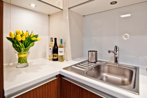 a kitchen with a sink and a vase of yellow flowers at Villa Aqua BlueApart Jurata in Jurata