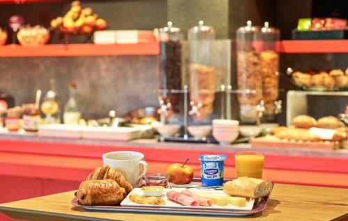 a tray of breakfast food on a table in a bakery at ibis Amboise in Amboise