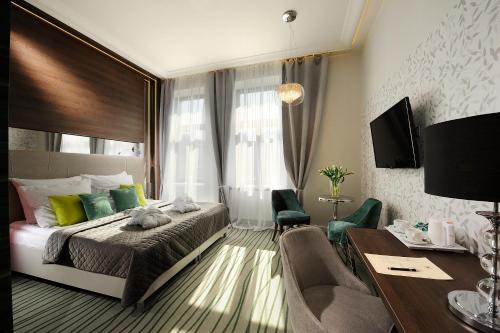 Pokój hotelowy z łóżkiem, biurkiem i pokojem w obiekcie Plaza Boutique Hotel w Krakowie