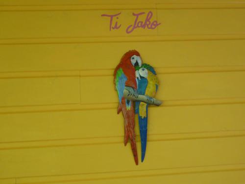 two parrots are sitting on a wall at Coco Bungalows in Sainte-Rose