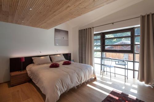 a bedroom with a large bed and a large window at Mineral Lodge & Spa in Villaroger