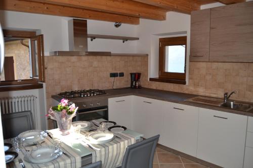 a kitchen with a table with a vase of flowers on it at Ca el Finilet in Brenzone sul Garda
