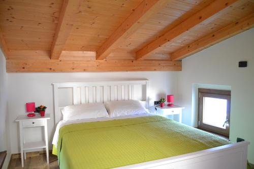 a bedroom with a large bed with a wooden ceiling at Ca el Finilet in Brenzone sul Garda