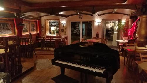 a piano sitting in a room with a restaurant at Hotel Restaurant Albans Sonne in Bad Rippoldsau