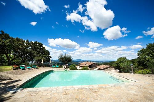 a swimming pool with a blue sky and clouds at Ripostena in Casole dʼElsa