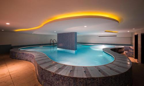 a pool in a hotel room with a large swimming pool at Boudl Al Tahlia in Jeddah