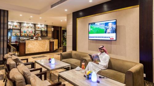 a woman sitting on a couch in a hotel lobby at Boudl Al Tahlia in Jeddah