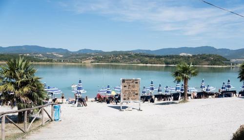 a beach with a bunch of umbrellas and a body of water at Camping Village Mugello Verde in San Piero a Sieve