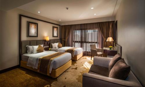 una camera d'albergo con due letti e un divano di Boudl Al Tahlia a Gedda