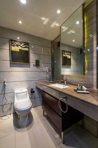 a bathroom with a toilet and a sink and a mirror at Boudl Al Tahlia in Jeddah