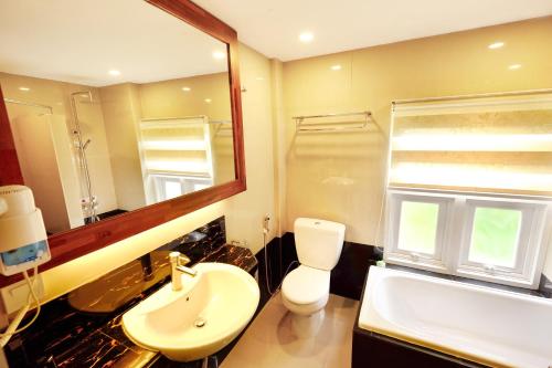 a bathroom with a sink and a toilet and a mirror at Sari Villa Ubud in Ubud