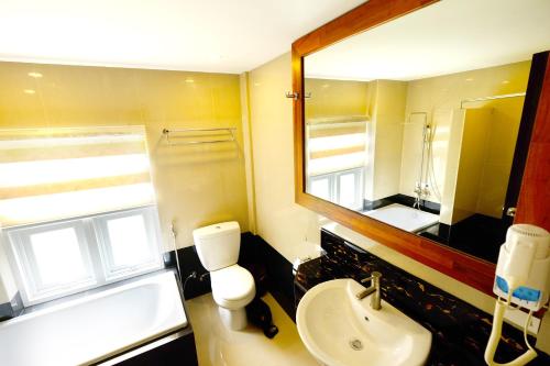 a bathroom with a toilet and a sink and a mirror at Sari Villa Ubud in Ubud