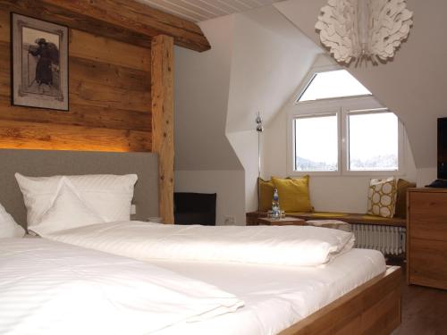
a bedroom with a bed and a window at Hotel Restaurant Peterle in Feldberg
