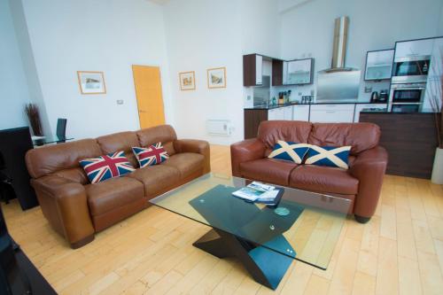 a living room with two leather couches and a coffee table at Ocean Serviced Apartments in Edinburgh