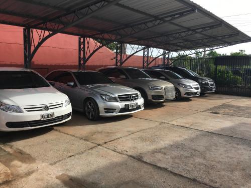 a row of parked cars in a parking lot at Hotel Las Residentas in Luque