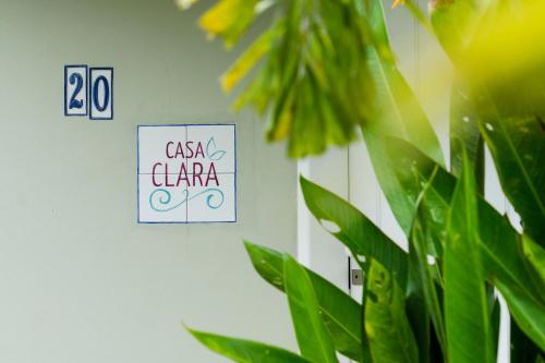 un panneau indiquant casa clara à côté d'une usine dans l'établissement Casa Clara Paraty, à Parati