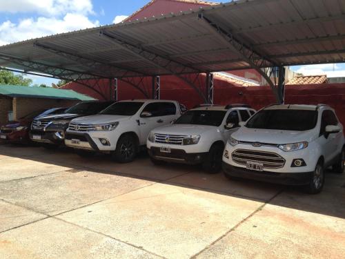 three cars parked in a parking lot at Hotel Las Residentas in Luque