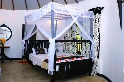 ein Schlafzimmer mit einem schwarzen Bett mit Baldachin in der Unterkunft Turtle Watch Cabana in Tangalle