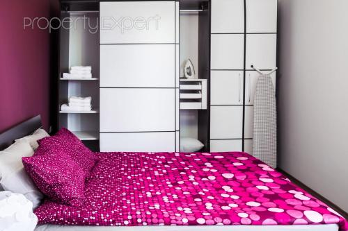 um quarto com uma cama grande e almofadas cor-de-rosa em The Heart of the city em Sófia