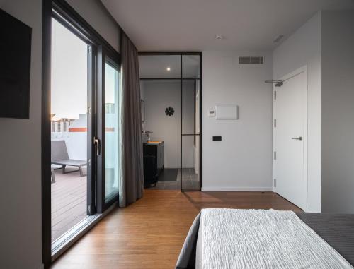 a bedroom with a bed and a sliding glass door at Welldone Antiquarium in Seville