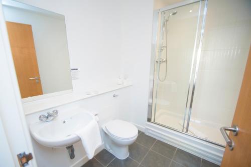 a bathroom with a shower and a toilet and a sink at Ocean Serviced Apartments in Edinburgh