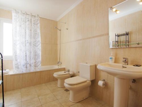a bathroom with a toilet and a sink and a tub at Holiday Home Pelzer by Interhome in Conil
