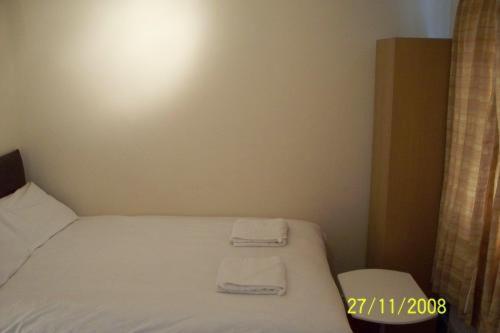 a bedroom with a bed with two towels on it at Citystay Hotel in London