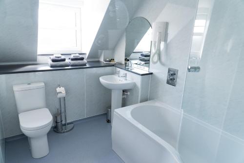 a bathroom with a sink, toilet and bathtub at Leys Hotel in Aberdeen