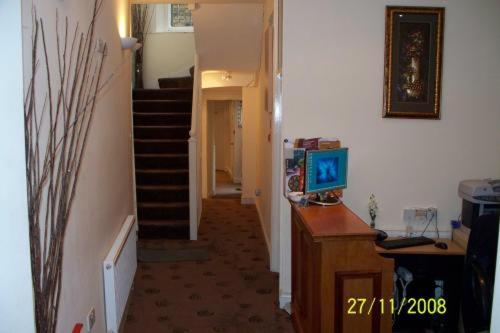 a hallway with a stairway leading to a room at Citystay Hotel in London