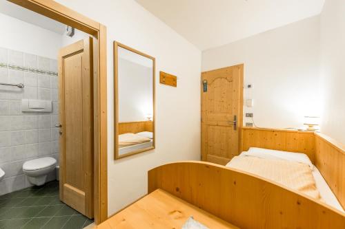 カンピテッロ・ディ・ファッサにあるGarni Tyroliaのバスルーム(ベッド1台、トイレ、鏡付)