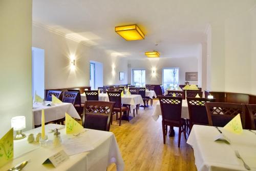 a dining room with white tables and chairs at Strandhotel Bansiner Hof in Bansin