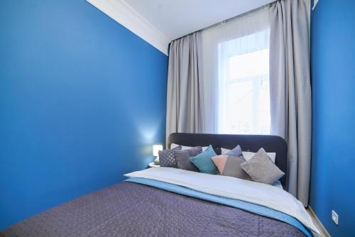 リヴィウにあるRomantic Apartment in the Сity Сenterの青いベッドルーム(窓付きのベッド付)