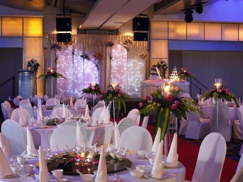 a banquet hall with white tables and chairs and lights at Furama City Centre in Singapore