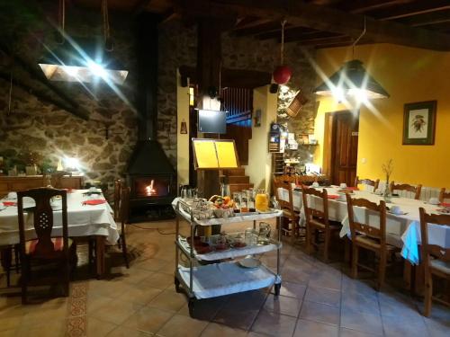 uma sala de jantar com mesas e cadeiras e uma lareira em La Trocha De Hoyorredondo em Hoyorredondo