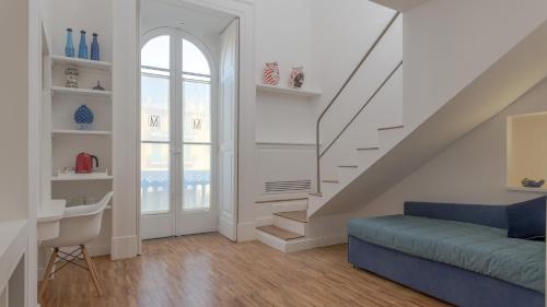 a living room with a staircase and a blue couch at Villa Manning Relais in Sorrento
