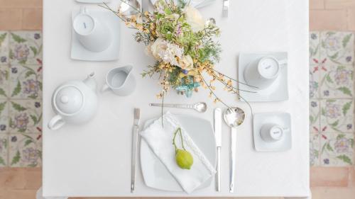a white table with a flower arrangement and a spoon at Villa Manning Relais in Sorrento