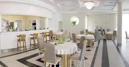a restaurant with tables and chairs in a room at Hotel Malwa in Ostrów Wielkopolski