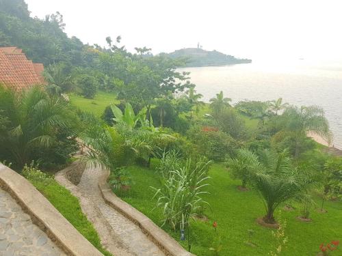 a view of the ocean from a resort with palm trees at Kivu Paradis Resort in Nyamyumba