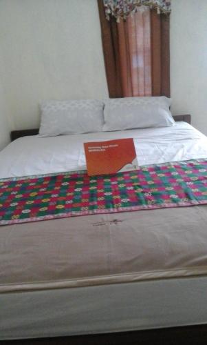 a bed with a sign on top of it at Pedek Homestay in Praya