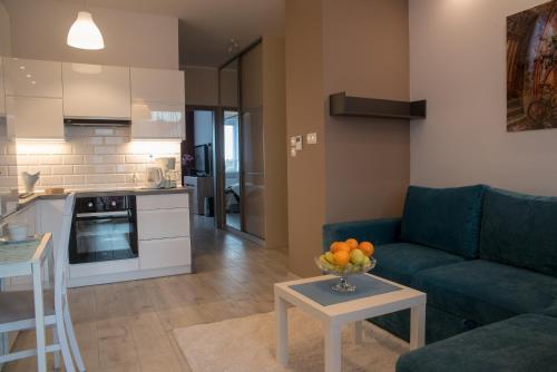 uma sala de estar com um sofá, uma mesa e uma cozinha em Apartament Piła Równa em Piła