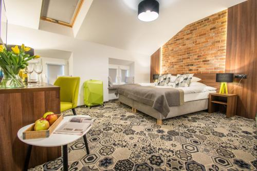 a bedroom with a bed and a brick wall at Hotel Lavender in Kraków