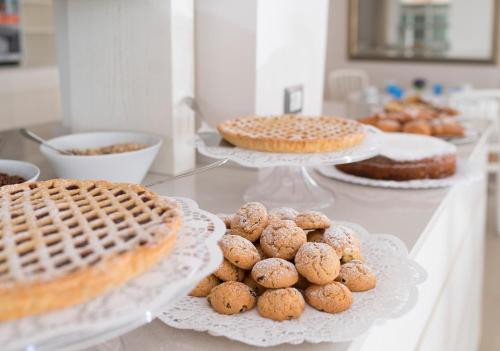 a buffet with cakes and pies and cakes on plates at Hotel Riviera in Bellaria-Igea Marina