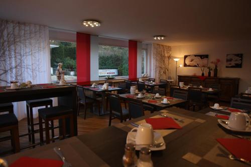 a restaurant with tables and chairs and a person walking in the background at Hotel Bürger in Siegen