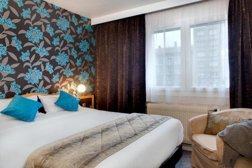 A bed or beds in a room at Logis Hôtel du Midi - Saint Etienne Sud
