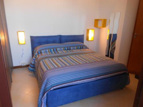 a blue bed in a room with two lights at B&B Verdeblu in Valderice