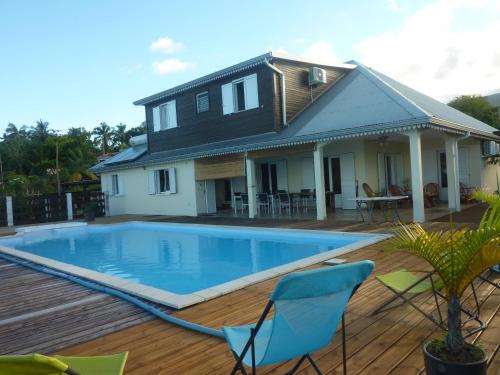 a house with a swimming pool in front of a house at La Pointe au Corail in Sainte-Rose