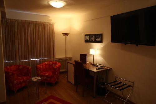 a hotel room with a desk and two chairs and a television at Hotel Bürger in Siegen