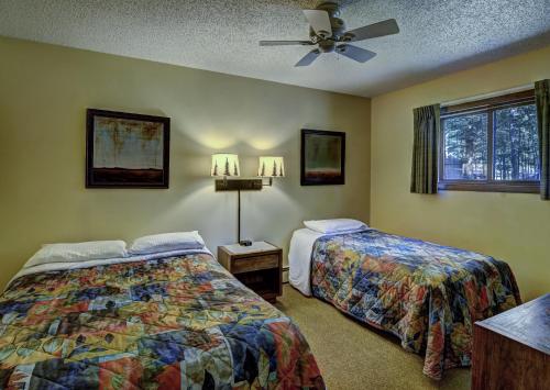 a bedroom with two beds and a ceiling fan at Lake Forest Resort in Eagle River